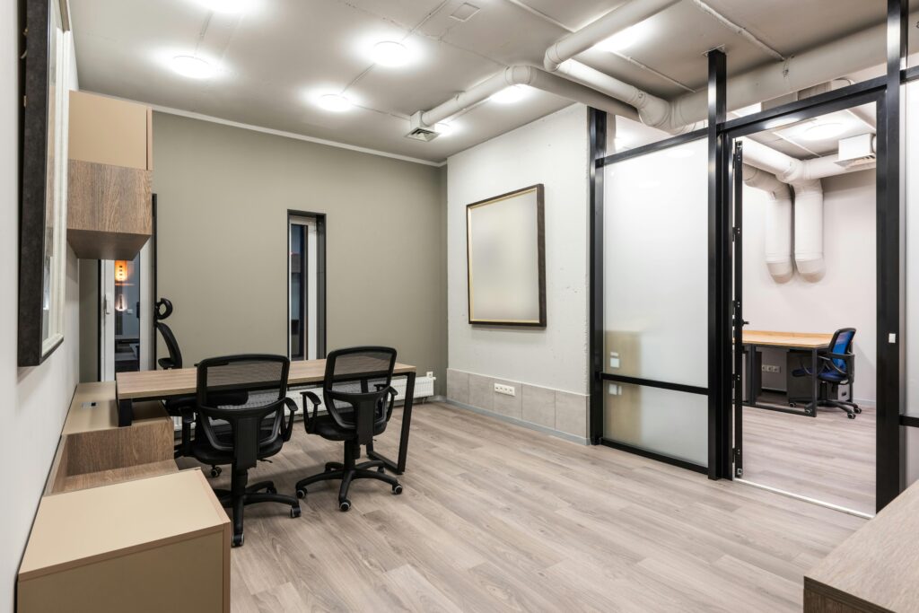 Spacious and tidy modern office interior with minimalist design, featuring sleek furniture and bright lighting.