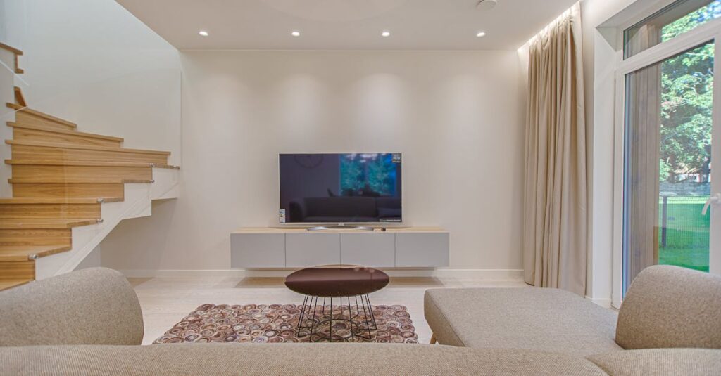 Contemporary living room with stylish sofa, TV, and staircase, offering a cozy interior design setting.